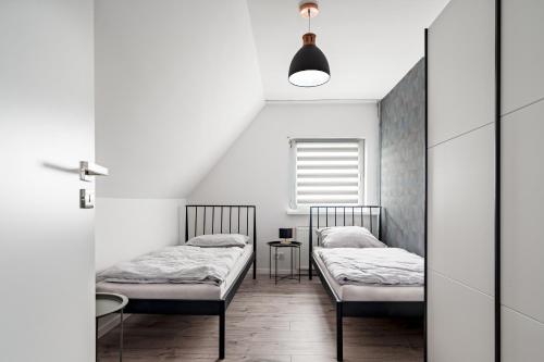 two beds in a room with a window at Noclegi Krańcowa in Zgorzelec