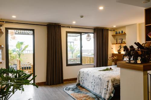 a bedroom with a bed and a large window at NALINI Hotel & Apartment in Da Nang