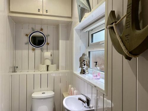 a bathroom with a toilet and a sink and a mirror at Kennedy House in Blackpool