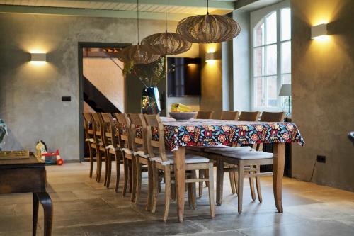 a dining room with a table and chairs at Hof van Kleeberg in Mechelen