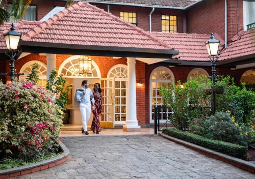 two women standing in front of a house at Fairmont The Norfolk in Nairobi