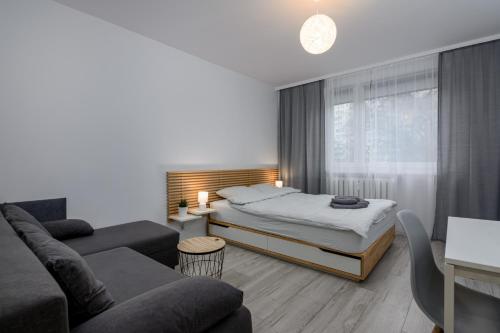 sala de estar con cama y sofá en Andersena Modern A - 10 min CMKP - 5 min Metro - 15 min Center en Varsovia