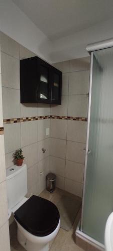 baño con aseo con tapa negra en Acogedor Estudio en Almagro, Buenos Aires en Buenos Aires