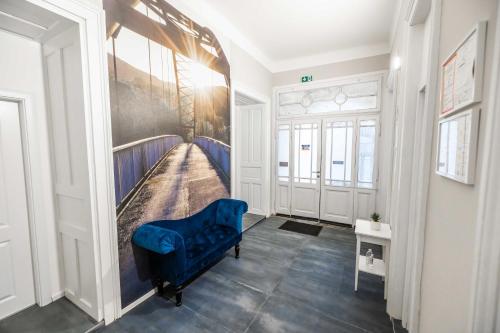 um corredor com uma cadeira azul num quarto em 4flats em Maribor
