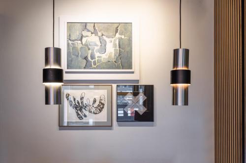 a wall with three pictures and two lights at Weber Hotel in Amsterdam