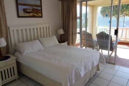 een slaapkamer met een wit bed en een balkon bij Laguna La Crete 47 in Margate