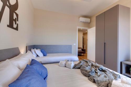 ein Wohnzimmer mit einem weißen Sofa und blauen Kissen in der Unterkunft Mamo Florence - Khione Apartment in Florenz