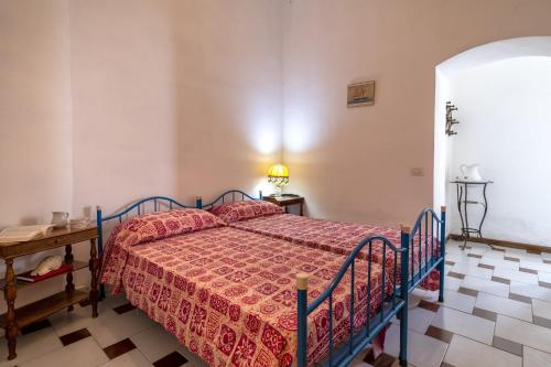 a bedroom with a bed with a red bedspread at Residence Capo Caccia Alghero in Alghero