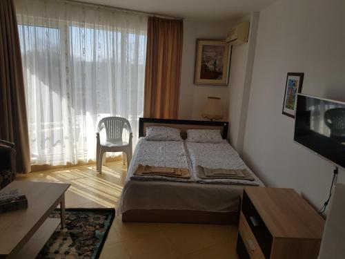 a bedroom with a bed and a table and a television at Midia Grand Rezort in Aheloy