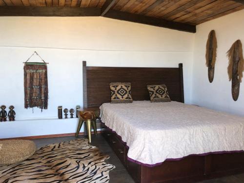 a bedroom with a large bed and a rug at Afrikan Krisant Tenerife, Casa Rural Ecologica in Arafo