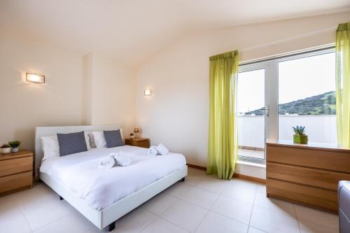 a bedroom with a bed and a large window at Burgau Beach House in Burgau