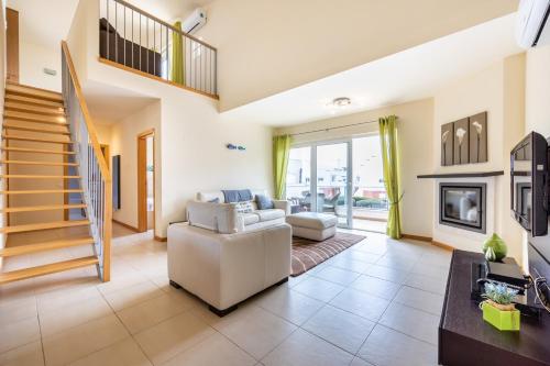 a living room with a couch and a fireplace at Burgau Beach House in Burgau