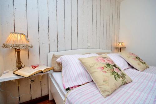 a bedroom with a bed and a lamp and a book at Bay House Rosohotnica in Vrboska