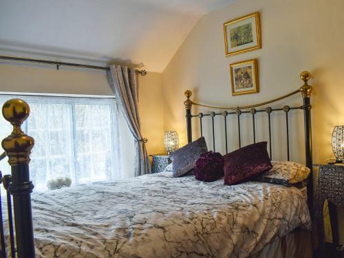 a bedroom with a bed and a large window at Borough Beck Cottage in Helmsley