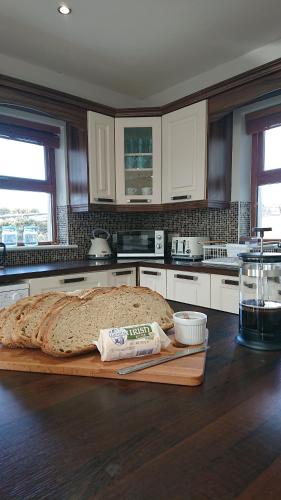 a kitchen with a cutting board with a loaf of bread at Melroche House Doolin in Doolin