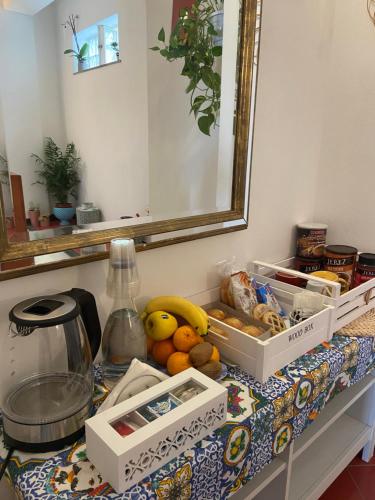 una mesa con frutas y otros artículos. en Taormina’s Sun, en Taormina