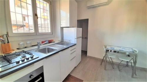 eine Küche mit einer Spüle und einem Kühlschrank in der Unterkunft Accomodo MIM23 Monolocale Navigli in Mailand