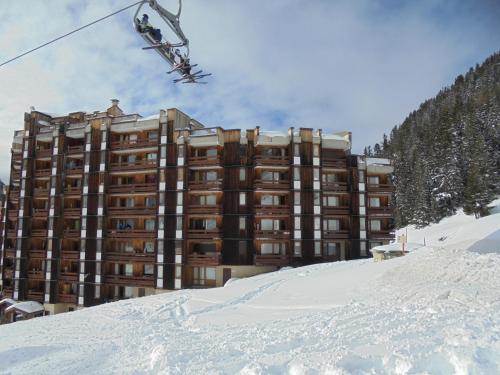 a person on a ski lift in front of a building at MON SKI A LA PLAGNE - PLAGNE BELLECOTE Résidence 3000 in Plagne Bellecote