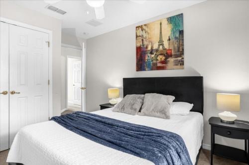 a white bedroom with a large bed and a painting on the wall at 3 Bedrooms 25 Bathrooms Encantada 3091 Yl in Orlando