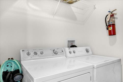 a white washing machine in a room with a fire extinguisher at 3 Bedrooms 25 Bathrooms Encantada 3091 Yl in Orlando