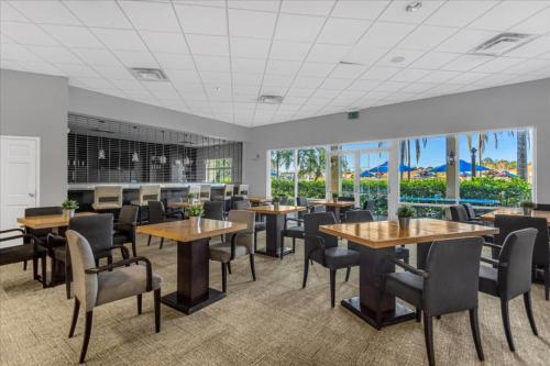a dining room with tables and chairs and windows at 3 Bedrooms 25 Bathrooms Encantada 3091 Yl in Orlando