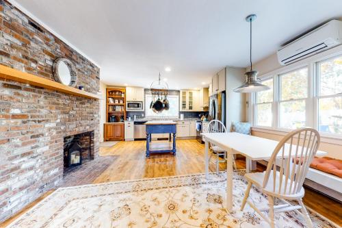 a kitchen and dining room with a brick fireplace at Pleasant Bay Retreat in Orleans