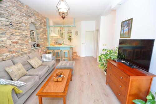 a living room with a couch and a tv at Bay House Rosohotnica in Vrboska