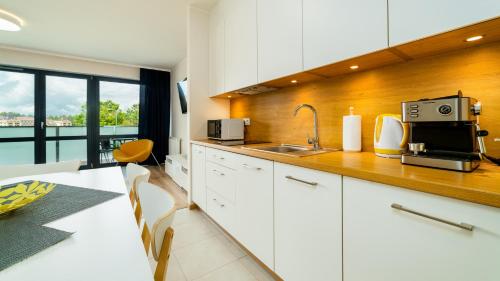 a kitchen with white cabinets and a counter with a microwave at Triventi Mountain Residence, Sun & Snow in Karpacz