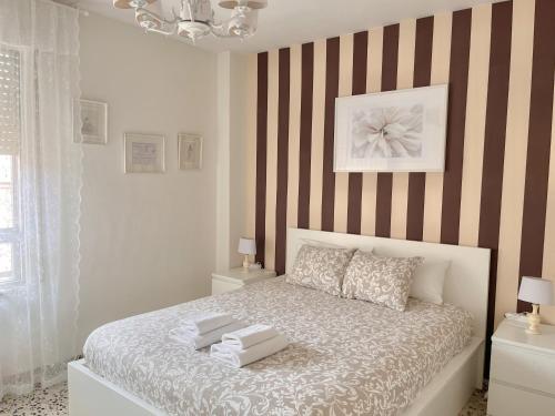 a bedroom with a bed with a striped wall at En Palencia capital céntrico con garaje Roberto in Palencia