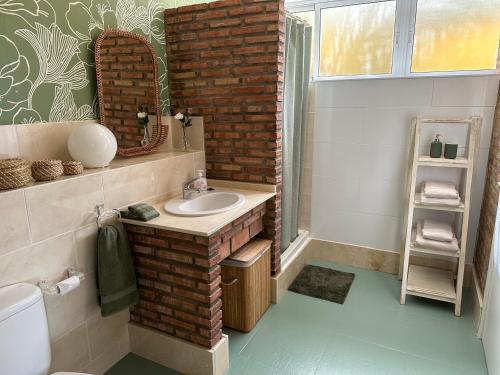 uma casa de banho com um lavatório e uma parede de tijolos em B&B Casa Oceo - Málaga - Andalusië em Alhaurín de la Torre