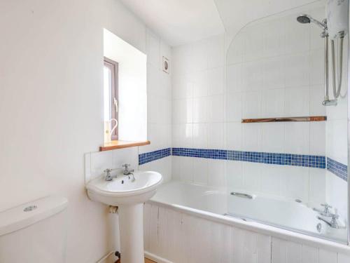 Beautiful 3 Bedroom Cottage -Cottage 5 في دونكاستير: حمام أبيض مع حوض وحوض استحمام
