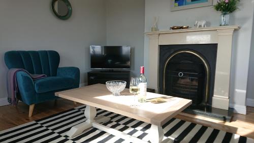 a living room with a table and a fireplace at Melroche House Doolin in Doolin