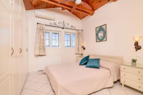 a white bedroom with a bed and a window at Étienne Apartment in Central Location in Zakynthos