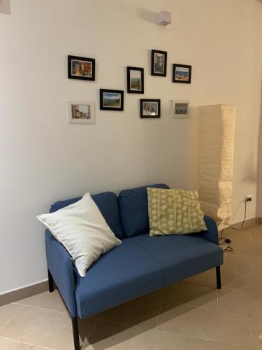 a blue couch in a living room with pictures on the wall at Galè Apartment in Bologna