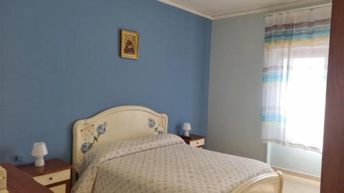 トッレ・アンヌンツィアータにあるApartment MariLùの青いベッドルーム(ベッド1台、窓付)