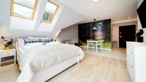 a bedroom with a large white bed in a attic at Triventi Mountain Residence, Sun & Snow in Karpacz