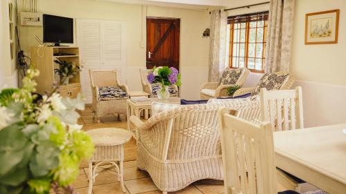 a living room with wicker chairs and a table at Redberry Farm in George