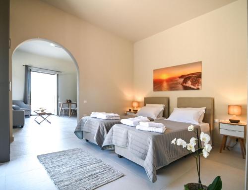 a bedroom with two beds and an archway at Villas Thalia in Zakynthos
