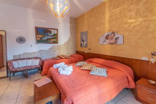 two beds in a bedroom with orange sheets at Spiagge Iblee in Marina di Ragusa