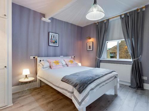 un dormitorio con una cama y una ventana en 1 King Street Accommodation, en Delph