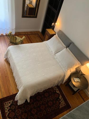 a large bed with white sheets and pillows in a room at Bohemian House in Milan