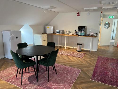 a room with a table and chairs and a kitchen at Mini-Hotel Borås Regementet in Borås