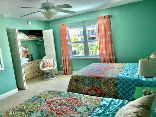 1 dormitorio con 2 camas y ventana en Condo By The Sea! en Cocoa Beach