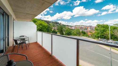 a balcony with a table and chairs and a view of a street at Triventi Mountain Residence, Sun & Snow in Karpacz