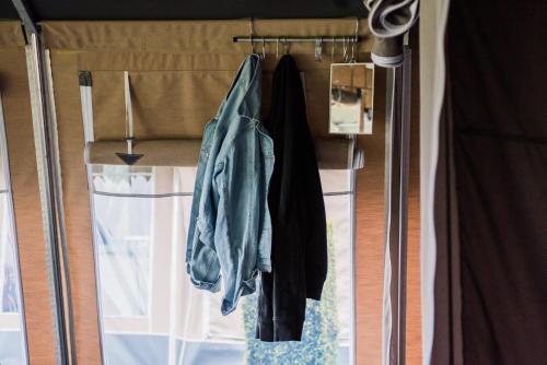 Zimmer mit einer Glasschiebetür mit hängenden Kleidern in der Unterkunft Country Camp Campeggio Paradiso in Viareggio