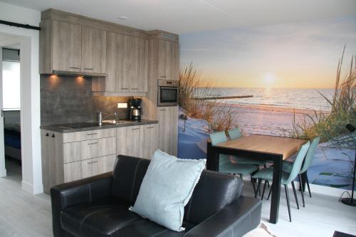 a kitchen and dining room with a couch and a table at Schorrebloem 2 in Nieuwvliet