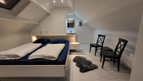 a bedroom with a bed and a desk and chairs at Schorrebloem 2 in Nieuwvliet