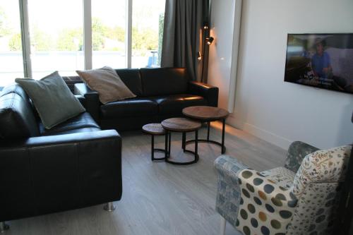a living room with couches and a table and chairs at Schorrebloem 2 in Nieuwvliet