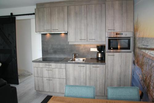 a kitchen with a sink and a microwave at Schorrebloem 2 in Nieuwvliet