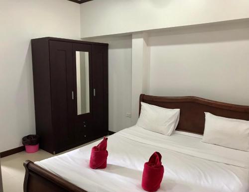 two red shoes sitting on top of a bed at TandT House in Lamai